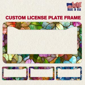 May include: Custom license plate frame with a colorful floral stained glass design. The frame features a vibrant mix of green, purple, and gold hues. The image also shows three smaller frames with different color variations.