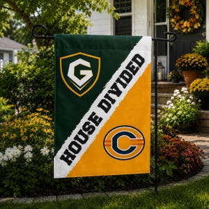 May include: A rectangular garden flag split diagonally into a dark green section with a yellow shield logo containing a white letter G and a yellow section with a navy blue letter C logo. The text HOUSE DIVIDED is printed in black along the diagonal.