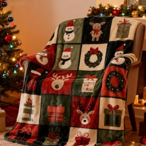 May include: A Christmas-themed throw blanket draped over a chair. The blanket features a patchwork design with squares of red, green, and cream colors. The squares display images of snowmen, reindeer, wreaths, and wrapped gifts. The blanket is made of a soft, plush material.