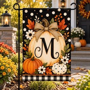 May include: A rectangular garden flag featuring a large central pumpkin with a burlap-style bow and the letter M in black. The design includes orange and white pumpkins, white flowers, autumn leaves, and a black background with white polka dots.