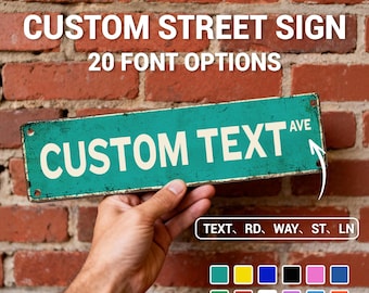 May include: A teal custom street sign with white text that reads "CUSTOM TEXT AVE". The sign is held in front of a brick wall. The text "CUSTOM STREET SIGN" and "20 FONT OPTIONS" are above the sign. Below the sign are color options.