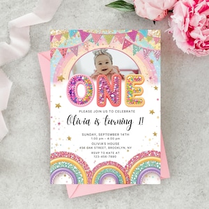 May include: A vibrant invitation for a first birthday party. The design includes a photo of a baby, the word "ONE" in large letters, and the text "Olivia is turning 1!" with event details. The invitation is decorated with rainbows and stars.