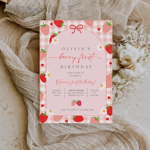 May include: A pink and white invitation card with a strawberry theme. The card features the text "Olivia's berry first birthday" and includes event details. Strawberries and floral accents decorate the card.