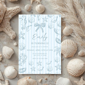 Könnte beinhalten: Eine hellblaue Einladungskarte mit maritimem Thema, verziert mit Zeichnungen von Muscheln, Seesternen und einem Seepferdchen. Der Text lautet "Emily wird 12" mit Veranstaltungsdetails. Die Karte ist von Muscheln und getrockneten Pflanzen umgeben.