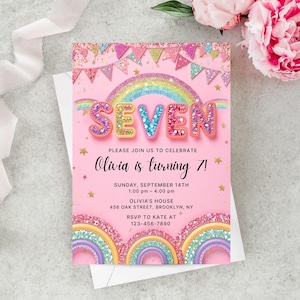 以下が含まれることがあります： ピンク色の誕生日招待状。虹とキラキラした「SEVEN」の文字が特徴です。「オリビアは7歳になります！」というメッセージと、日付、時間、場所などのイベント詳細が記載されています。 RSVP情報も含まれています。