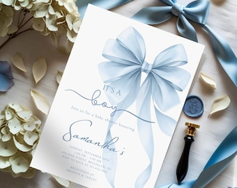 May include: Baby shower invitation with a light blue bow and the words "It's a boy." The invitation includes details for the event, such as the date, time, and location. A wax seal and ribbon are also visible.