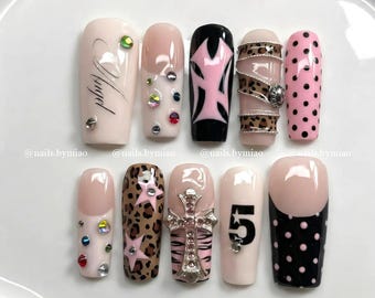 Kruis luipaardpers op nagels: strass-nagels, steraccent en Y2K-gotische details