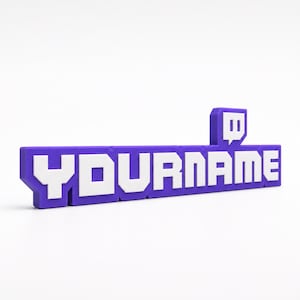 Könnte beinhalten: Ein dreidimensionales Schild mit dem Text YOURNAME in fetten weißen Blockbuchstaben mit violettem Rand. Das Design enthält ein kleines violett-weißes Sprechblasensymbol mit zwei vertikalen Linien, das über dem Buchstaben E positioniert ist.