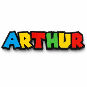 Pu&ograve; includere: Targhetta colorata con il nome "ARTHUR" in lettere 3D. Le lettere sono blu, gialle, rosse, verdi, gialle e rosse, con contorno nero. Un oggetto decorativo, adatto per una cameretta.