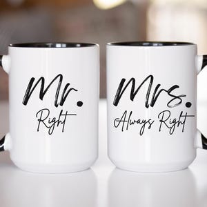 May include: Two white ceramic mugs with black rims and handles. The mug on the left says "Mr. Right" and the mug on the right says "Mrs. Always Right".