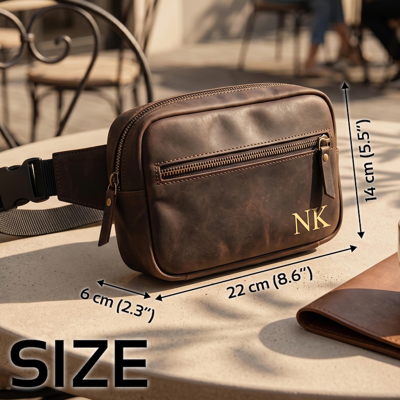May include: A brown leather fanny pack with a front zipper pocket and the gold-colored initials NK. The bag features a black adjustable strap with a plastic buckle. Dimensions are 8.6 inches wide, 5.5 inches high, and 2.3 inches deep.