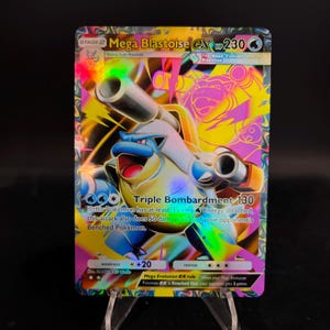 Puede incluir: Una tarjeta coleccionable holográfica Mega Blastoise EX. La tarjeta presenta un personaje Blastoise azul y blanco con cañones grandes, sobre un fondo vibrante de color rosa, amarillo y morado. El texto incluye "Triple Bombardment 130".