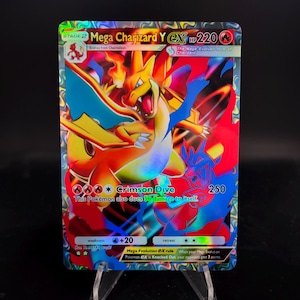 May include: A holographic Mega Charizard Y EX Pokémon card. The card features a fiery orange and yellow Charizard with blue wings, and the text "Crimson Dive". The card has a HP of 220 and a damage value of 250.