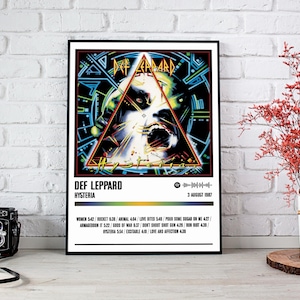 May include: A minimalist poster with a black frame featuring the album cover for Def Leppard's "Hysteria" album. The album cover features a stylized image of a face with a triangle design. The poster includes the album title, band name, and release date: 3 August 1987. The poster also lists the album's tracklist with song titles and lengths.
