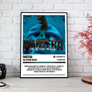 May include: A framed poster featuring the album art for Pantera's "Far Beyond Driven." The artwork has a blue skull design with the band's name in a distressed font. The poster includes the album title, tracklist, and release date.