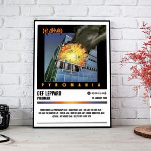 May include: A black and white poster with a photo of a building on fire. The text "Def Leppard" and "Pyromania" is in white letters on a black background. The album release date is "20 January 1983". The album track list is also included.