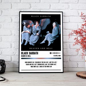 Könnte beinhalten: Ein Schwarzweiß-Poster mit einem Foto der Band Black Sabbath. Das Poster zeigt den Bandnamen und den Albumtitel "Heaven and Hell" in weiß gedruckt. Das Erscheinungsdatum des Albums, "18. April 1980", ist in weiß unter dem Albumtitel gedruckt. Die Tracklist des Albums ist in weiß unter dem Erscheinungsdatum gedruckt.