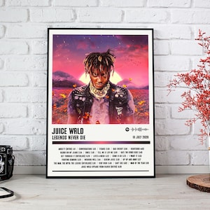 以下が含まれることがあります： Juice WRLDのアルバム「Legends Never Die」のフレーム入りポスター。鮮やかな夕焼けを背景に、アーティストの肖像画が描かれています。ポスターにはアルバムタイトル、トラックリスト、2020年7月10日の日付が含まれています。
