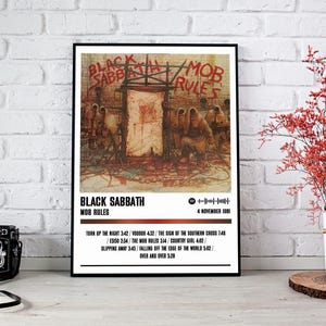 May include: A black and white poster with a minimalist design featuring the band Black Sabbath. The poster has the album title "Mob Rules" and the release date "4 November 1981". The poster also includes a list of the songs on the album.