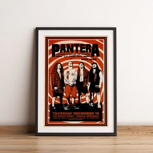 May include: Framed concert poster for Pantera's Vulgar Display of Power U.S. Tour 1992, featuring the band members. The poster has a red and white spiral background with black text. The concert date is Thursday, December 10 at The Ranch Bowl in Omaha, Nebraska.