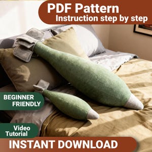 May include: Two plush pillows shaped like bombs in a soft green fabric with grey fin details at the base and a grey pointed tip. The image includes text stating PDF Pattern, Instruction step by step, BEGINNER FRIENDLY, Video Tutorial, and INSTANT DOWNLOAD.