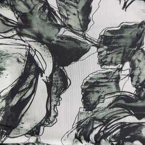 May include: Abstract floral print fabric in shades of black and green on a white background. The design features large, flowing shapes that resemble flowers or leaves.