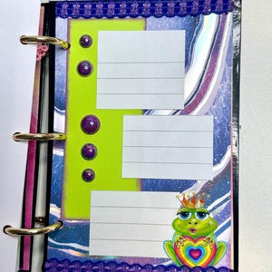 Puede incluir: Una p&aacute;gina de planificador colorida con una secci&oacute;n verde lima con tres cuadros rayados para notas. Acentos de gemas moradas y un borde decorativo enmarcan la p&aacute;gina. Una rana de dibujos animados con una corona y un coraz&oacute;n est&aacute; en la esquina.
