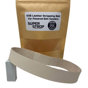 Könnte beinhalten: Ein beiger Leder-Schleifriemen für motorbetriebene Bandschleifer, verpackt in einer braunen Papiertüte. Die Tüte trägt ein Etikett mit der Aufschrift "1x18 Leather Stropping Belt for Powered Belt Sanders" und "SUPER STROP PREMIUM LEATHER HONING BELTS" mit einer "Made in USA"-Flaggengrafik.