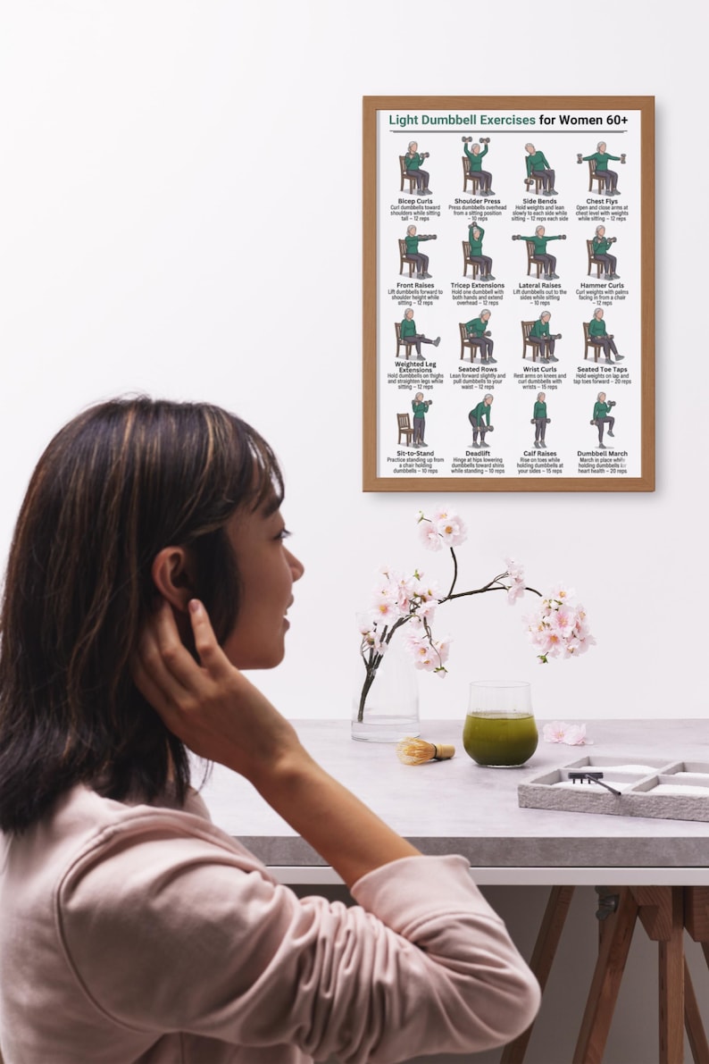 May include: A framed poster titled "Light Dumbbell Exercises for Women 60+" displays illustrations of various exercises. The poster is brown and hangs on a white wall. A woman is seen in the foreground, with a table holding a glass of green liquid and flowers.