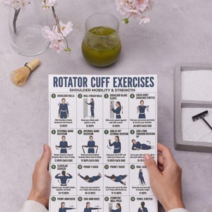 May include: A white exercise chart titled "Rotator Cuff Exercises" with illustrations of shoulder mobility and strength exercises. A glass of green liquid and pink flowers are in the background.