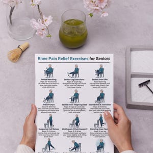 May include: A printed guide titled "Knee Pain Relief Exercises for Seniors" is held by a person. The guide features illustrations of exercises, a glass of green liquid, and a matcha whisk. Cherry blossoms are in the background.