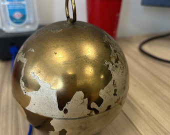 Portasigarette/dispenser a forma di globo in ottone, stile vintage di metà secolo, probabilmente prodotto negli anni '50 o '60.