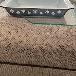 May include: A gray rectangular baking dish with a light blue interior and a white snowflake pattern around the rim.