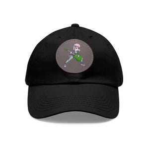 May include: Black baseball cap with a round patch featuring a cartoon character playing a green electric guitar. The character has pink hair and is wearing a black leather jacket.