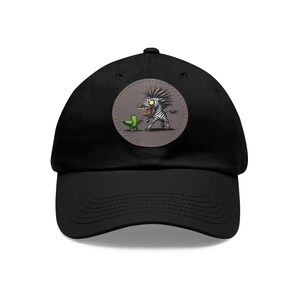 May include: Black baseball cap with a round patch featuring a cartoon zebra with a green pickle. The zebra has a surprised expression and is holding a knife.