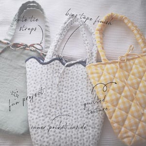May include: Three handmade tote bags in pastel colors. One is light green with tie straps, another is white with a floral pattern, and the third is yellow with a quilted texture. The bags have bias tape finishes and inner pockets.