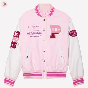 May include: Pale pink varsity jacket with white sleeves. It has the letter "P" and the text "The 5 Rules of Pink" embroidered on the front. The left sleeve has the numbers "13" and "16". The right sleeve has a patch that says "Love Shack".