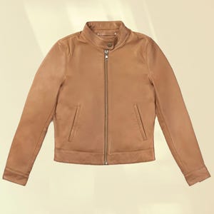 Puede incluir: Chaqueta de cuero marr&oacute;n claro con cuello alzado y cremallera completa. La chaqueta tiene dos bolsillos delanteros y mangas largas. La chaqueta es de color neutro y es adecuada para varios conjuntos.