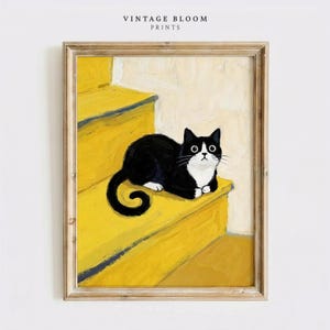 May include: Framed art print featuring a black and white cat resting on a bright yellow staircase. The cat has wide eyes and a white chest. The artwork is labeled "VINTAGE BLOOM PRINTS" at the top.