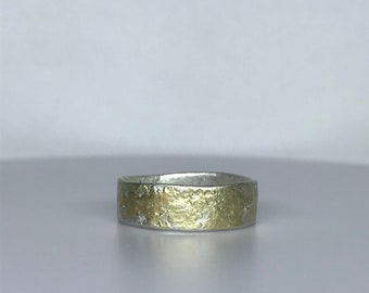 Sterling silver and 18ct gold rustic ring with a molten surface texture.