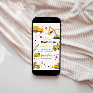 May include: A yellow and black construction themed birthday invitation for a child turning two. The invitation features a phone screen with a white background and yellow construction vehicles, including a cement mixer, a crane, a dump truck, and an excavator. The text on the invitation reads "The traffic close the road Maddox is turning two years old! Come join the crew. It will be loads of fun! Saturday, June 22, 20XX PM Maddox's Construction Site 123 Party Lane, Texas 4567 RSVP to Amy at 123.456.789"