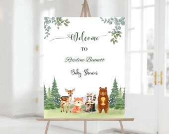 Op de afbeelding: Welkom bij de babyshower van Roselina Bennett met een bos-thema. Het bord toont een hert, een vos, een wasbeer en een beer in een bosrijke omgeving met groene bladeren en bomen.