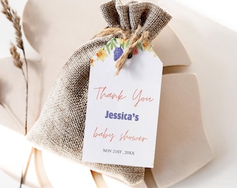 May include: A white thank you tag with floral border and the text "Thank You Jessica's baby shower NOV 21ST, 20XX" attached to a burlap gift bag.
