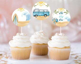 May include: Three cupcake toppers with a beach theme. The toppers feature a blue and white van, a surfboard, and the text "The Big One".