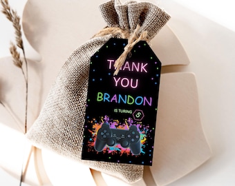 May include: Black thank you tag with neon pink, green, and blue text that reads "Thank You Brandon is Turning 5". The tag features a black video game controller on a black background with colorful splatters.