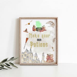May include: A framed print with a watercolor illustration featuring a castle, books, a cauldron, and a broom. The text "Make your own Potions" is displayed in gold lettering. Other elements include a golden snitch, owl, glasses, and a key.