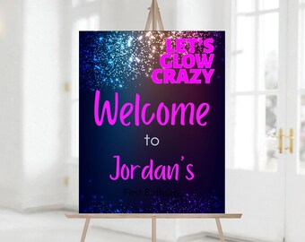 May include: A neon blue and purple glow-in-the-dark welcome sign with the text "Let's Glow Crazy" and "Welcome to Jordan's First Birthday".
