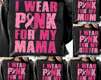May include: A dark gray sweatshirt with the text "I WEAR PINK FOR MY MAMA" in distressed pink lettering. A pink ribbon graphic is also present. Other sweatshirts in the image say "MOM", "SISTER", "WIFE", "GRANDMA", and "AUNT".
