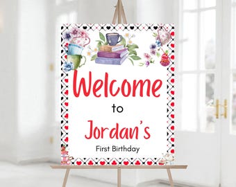 May include: Welcome to Jordan's First Birthday sign with a white background and red hearts, black spades, and a whimsical tea party illustration.