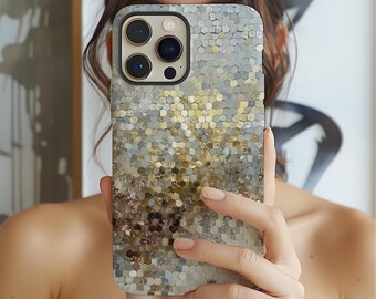 May include: A smartphone case with a mosaic design in shades of gray, gold, and brown. The case has a hexagonal pattern and a glossy finish. The phone case is held in front of a person's face.